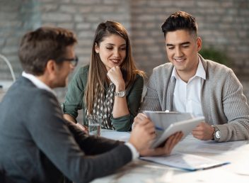 Young happy couple having consultations with bank manager on a meeting in the office.